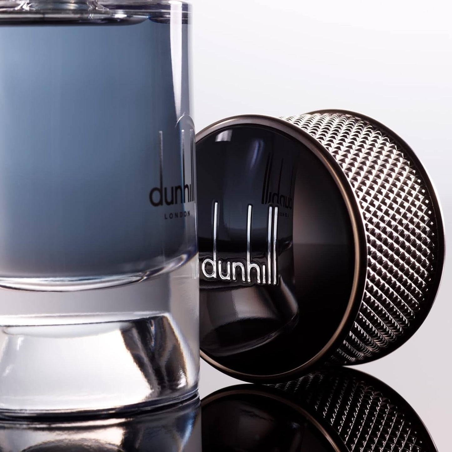 Dunhill London perfume bottle with cap on a reflective surface