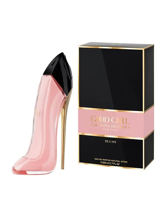 Pink high-heeled shoe-shaped perfume bottle with black cap next to its packaging on a white background