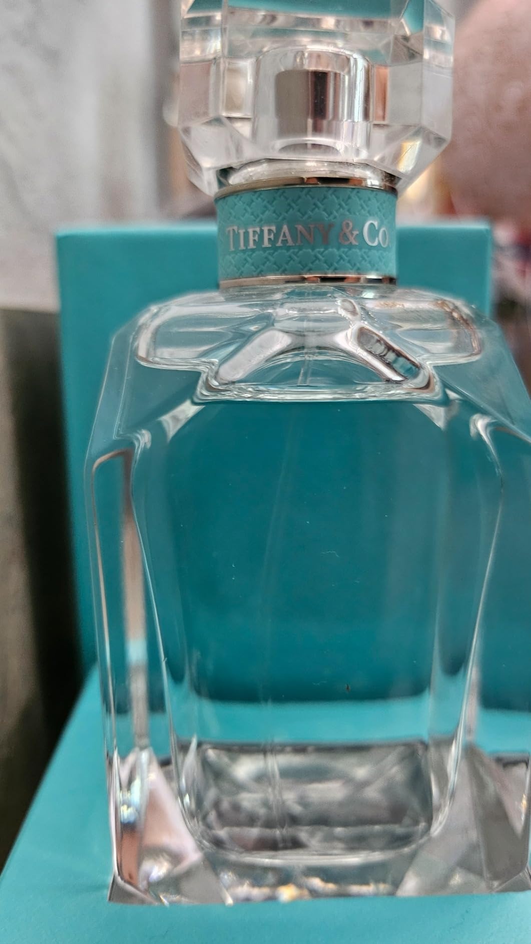 Tiffany & Co. perfume bottle on a blue surface